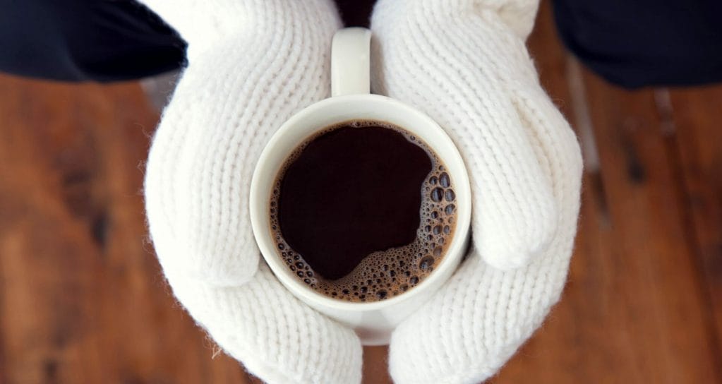winter sunday morning with coffee in white mittens