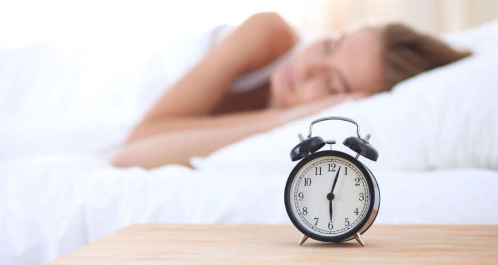 Insomnia Bootcamp Sleeping woman with alarm clock
